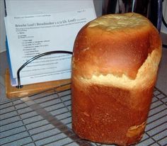 a loaf of bread sitting on top of a cooling rack next to a piece of paper