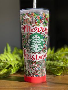 a starbucks cup with sprinkles and merry christmas written on it