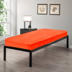 an orange bed is in the middle of a room