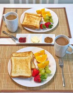 two white plates topped with toast and fruit next to a cup of coffee on top of a table