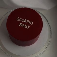 a red cake with the words scorpio baby on it sitting on a plate