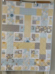 a blue and yellow quilt hanging on a wall