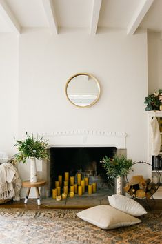 a living room filled with furniture and a fire place under a mirror on the wall