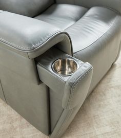 a grey leather recliner with a bowl in it