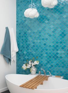 a white bath tub sitting next to a blue wall