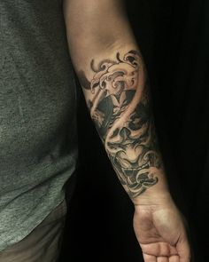 a man with a tattoo on his arm holding the hand of another person's wrist