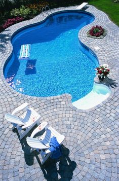 an empty swimming pool with lounge chairs around it