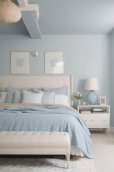 a bedroom with blue walls, white furniture and pictures on the wall above the bed