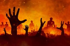 silhouettes of people with hands up in front of an orange and black background that appears to be burning