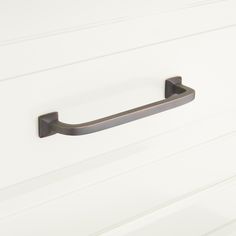 a close up of a door handle on a white cabinet