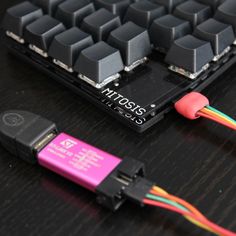 a close up of a computer keyboard with two wires attached to the keys and an external key board