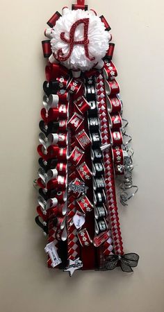 a wall hanging made out of soda cans and ribbon with the letter d on it