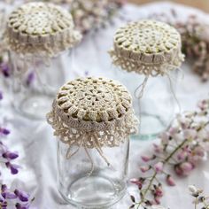 crocheted doily in glass jars with lavender flowers on the table behind them