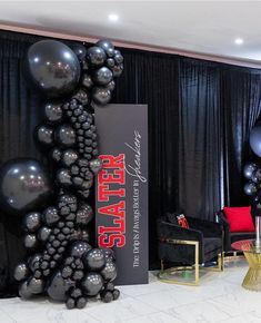 black balloons are on display in front of a stage set up for a party or event