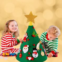 two young children playing with a christmas tree ornament in front of a gold background