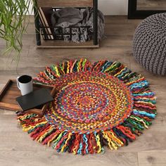 a multicolored rug is on the floor next to a coffee cup and pen