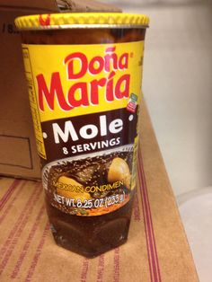 a container of marmalade sitting on top of a table next to a cardboard box