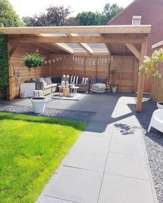 an outdoor patio area with wooden pergolan and white furniture in the back yard