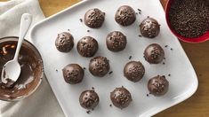 chocolate truffles on a plate with a spoon and bowl of sprinkles