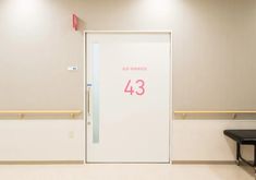 a white door with the number 43 written in pink on it next to a bench