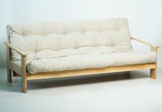 a white futon couch sitting on top of a wooden frame