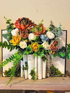 an arrangement of flowers and books on a table