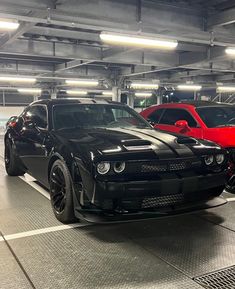 two black and red cars in a parking garage