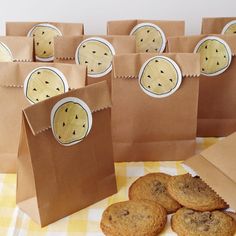 cookies and chocolate chip cookies in brown paper bags on a yellow checkered tablecloth