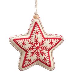 a red and white star ornament hanging from a string on a white background