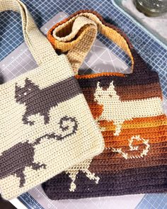 two crocheted bags sitting on top of a table