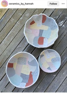 two bowls sitting on top of a wooden table next to each other with different colored designs