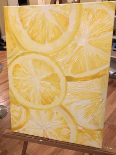 a painting of lemons on an easel in the process of being painted with acrylic paint