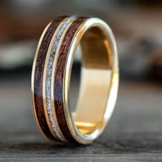 a wedding ring with wood inlays and two tone gold rings on the inside