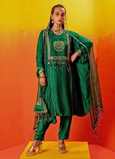 Introducing the stunning Green Embroidered relaxed fit Kurta Pant Set, crafted from luxurious vegan satin and organza silk. The rich green kurta features intricate hand embroidery with gold sequins, zari, and pearl bead detailing, enhanced by a signature motif. Paired with slim pants and completed with a dupatta adorned with all-round sequin lace and handcrafted beaded tassels, adding a final touch of sophistication. Ideal for Mehndi, weddings or festive events, this Indo-Western outfit ensures a standout appearance at any occasion. Composition : Top, Bottom - Vegan Satin and Dupatta - Silk Organza Care: Dry Clean Only and Vacuum Storage This product can be customized for sleeves, blouse length and neckline Delivery : 2-4 weeks as the product is hand crafted. Check Size Guide or choose MyS Luxury Green Embellished Kurta, Green Embellished Festive Kurta, Luxury Green Straight Kurta Pant Set, Fitted Green Kurta With Embroidered Border, Semi-stitched Embellished Green Kurta, Stylish Drapes, Kurta Pant Set, Vacuum Storage, Sleeves Blouse