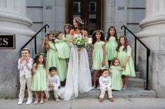 a group of people standing next to each other in front of a building with flowers on their heads