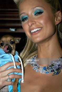 a woman holding a small dog in her arms and smiling at the camera stock photo