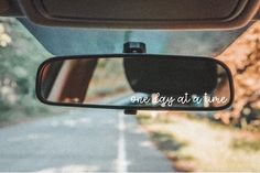 the rear view mirror of a car is shown with one day at a time written on it