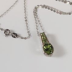 Peridot 1.0 Carat Pendant Necklace With Accent Peridot Gemstones. Plus, The Sparkling Chain Is Quality Italian Made And Is Stamped 925 Italy Chrysos. The Peridot Main Stone Is Approximately 1 Carat. Measurement Of The Peridot Gemstone Is 7x5 Mm Oval Cut And Faceted. The Drop Pendant Style Setting Was Created With Nice Detail. In Addition There Are Three Peridot Stones Above The Main Stone Measuring 3 Mm, 2.5mm And 2 Mm. All Accent Stones Are Round Cut And Faceted. The Main Peridot Size With Accent Stones Creates A Nice Hanging Presence. Spring Clasp Closure. Platinum Over Sterling Silver Adds Luster And Protection. New Without Tags In Gift Bag. (429) Italian Chain, Peridot Stone, Peridot Gemstone, Drop Pendant, 1 Carat, Oval Cut, Chains Necklace, Size 20, Gift Bag