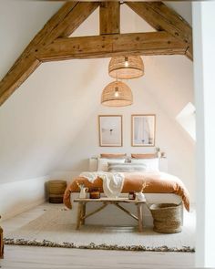 a bed sitting under a wooden beam in a bedroom next to a table and chair