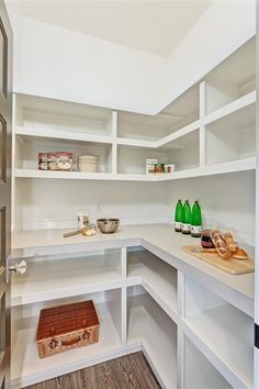 a kitchen with white shelving and wooden flooring