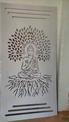 a white door with an image of buddha sitting in the center and roots growing out of it