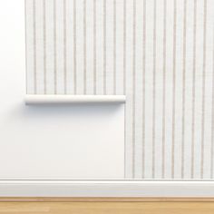 the corner of a room with a white wall and beige striped wallpaper on it