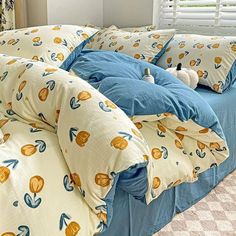 a bed with blue and yellow comforters on it