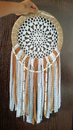 a person is holding up a doily with beads on it