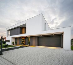 a large white house with two garages on the front and one door open to let in light