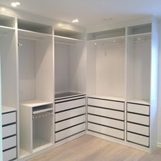 an empty walk in closet with white drawers and black stripes on the bottom shelfs