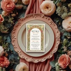 a table setting with pink flowers and an ornate menu card on the centerpieces