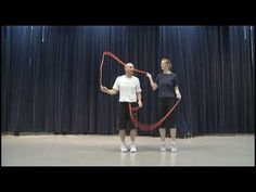 two people standing in front of a curtain with a large red ribbon attached to them