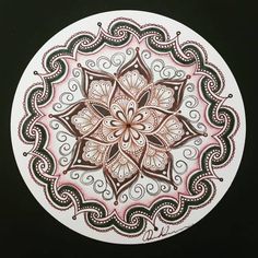 a drawing of a flower in brown and pink on a white circle with swirls