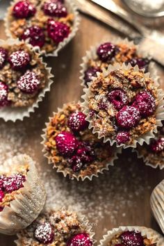 small cupcakes with cranberry topping on a wooden table next to silverware